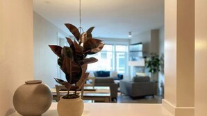 A modern living room with a sofa, a coffee table, and a plant in a vase. - Steps to Pike Place 2BD Condo Water Courtyard View (Seattle)