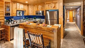 A wooden cabin interior with a kitchen, dining area, and a hallway. - Abode at Black Bear #104, private hot tub, pool & gym, Deer Valley (Park City)