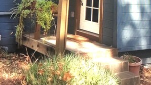 Ein Holzhaus mit Veranda, Tür und Fenstern.