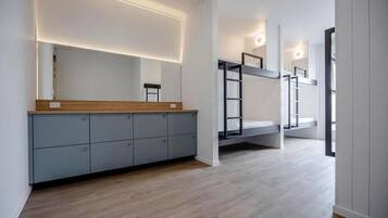 A modern interior with a bunk bed, grey cabinets, and a wooden counter.