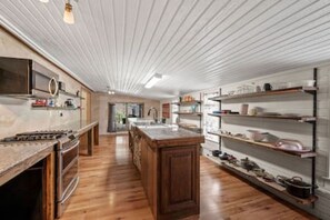 A kitchen with wooden cabinets, a central island, and built-in shelves.
