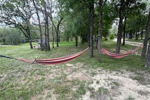 Una cadira espanyola tendida entre arbres en una zona boscosa.