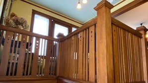 A wooden balcony with vertical slats and a balustrade.