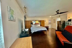 A bedroom with a bed, a desk, a chair, and a sofa. - FW Studio | Pool + Desk | Near TX Speedway (Fort Worth)