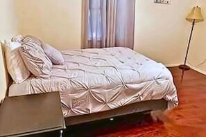 A bedroom with a bed, a nightstand, and a lamp. - FW Pool + Arcade - Fun Near TX Speedway (Fort Worth)