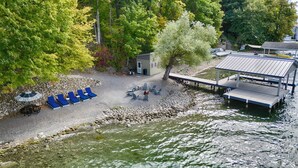 Un lieu de détente au bord du lac, avec des chaises longues, un petit bâtiment et une jetée qui s’avance dans l’eau.