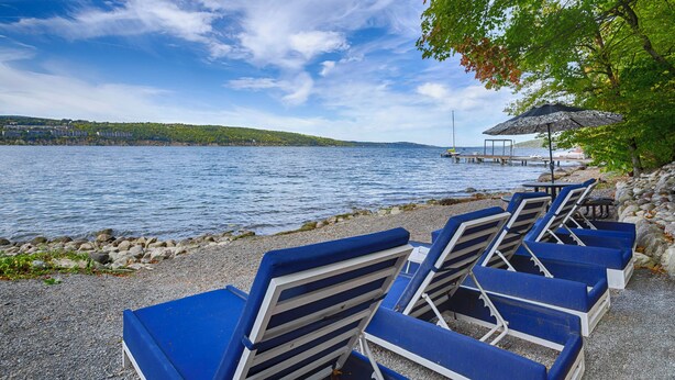 Un cadre idyllique au bord du lac, avec des chaises longues bleues et une jetée en bois qui s’avance dans l’eau.