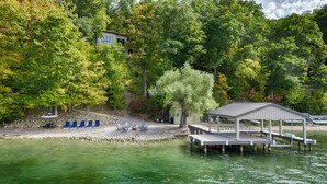 Une propriété au bord du lac, dotée d’un quai, de chaises longues et d’un pavillon abrité.