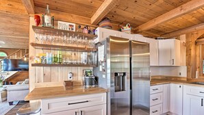 A modern kitchen with white cabinets, stainless steel appliances, and wooden countertops. - Updated Glen Arbor Cottage on Lake: Dock & Mooring (Glen Arbor)