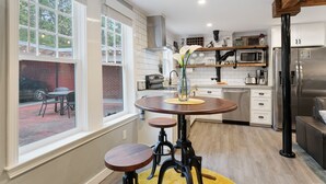 A modern kitchen with a central island, white cabinetry, and a view of the outside. - Belhaven Arts Hideaway: Private Suite + Walkable (Jackson)