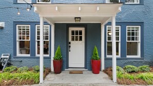 A blue building with a white door and two potted plants on the porch. - Belhaven Arts Hideaway: Private Suite + Walkable (Jackson)