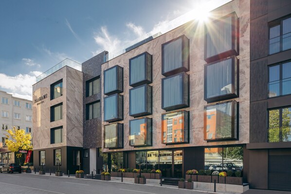 Um hotel moderno com fachada de vidro, grandes janelas e design limpo e contemporâneo.