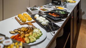 A buffet with various dishes including vegetables, meats, and desserts. - Hotel MANAMI (Pristina)