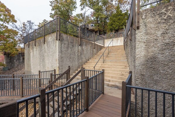 A staircase with wooden railings and stone walls, leading to a higher level.