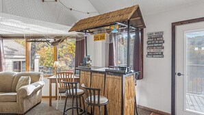 Un interior acogedor con una zona de bar, un sofá y una mesa de comedor.