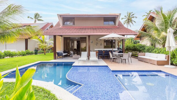 A two-story house with a swimming pool, outdoor seating, and palm trees. - OKA BEACH RESIDENCE Porto de Galinhas (Ipojuca)