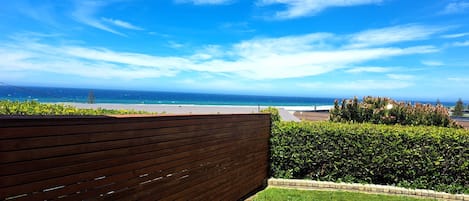 A balcony with a view of the ocean and a clear sky.
