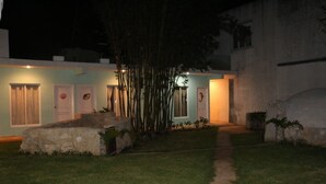 A building with a pathway leading to a set of doors, surrounded by a small garden and bamboo plants. - Charming 5-Bed Villa in Cancún (Cancún)