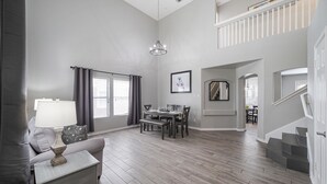A spacious living room with a dining area, a staircase, and a view of the city. - ACL Super Home  . 4 bedroom with Hot spa in the backyard in an awesome neigbohoo (Round Rock)