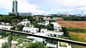 A residential area with modern houses, a large open field, and a tall building in the background. - Laguna Beach 3 The Maldives - top floor studio (Pattaya)