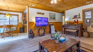 A cozy living room with a television, a piano, and a fireplace. - Romantic Couple's Retreat steps from Village, Kid-Friendly, Fireplace, WiFi (Big Bear Lake)