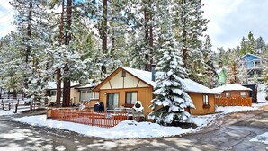 A cabin with a wooden exterior, surrounded by snow-covered trees. - Romantic Couple's Retreat steps from Village, Kid-Friendly, Fireplace, WiFi (Big Bear Lake)