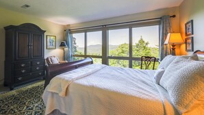 A bedroom with a large bed, a dresser, and a view of the outdoors. - Breathtaking Highlands Condo w/ Mountain View (Highlands)