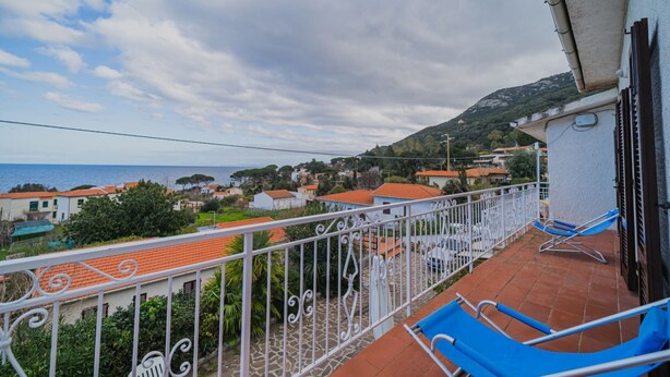 Ein Balkon mit Blick auf das Meer und eine Stadt.