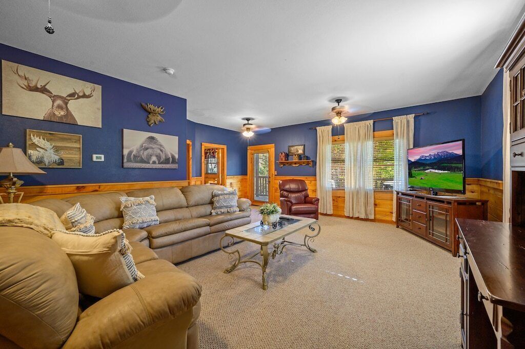 A cozy living room with a brown leather sofa, a coffee table, and a television.