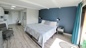 Un dormitorio con cama, mesitas de noche, un escritorio y una silla.