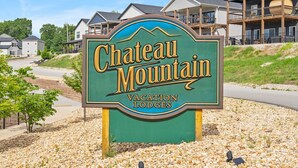 Schild für Chateau Mountain Vacation Lodges mit Blick auf Wohnhäuser im Hintergrund.