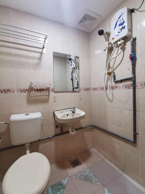 Un baño pequeño con inodoro, lavamanos y ducha.