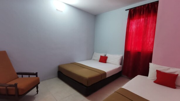 A hotel room with two beds, a chair, and a red curtain. - Hotel O My Seven Days Inn (Masai)