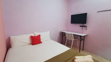 A room with a bed, a desk, and a television.