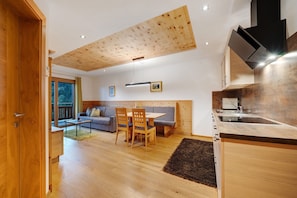 Une cuisine moderne avec des meubles en bois, un coin repas comprenant une table et des chaises, et un banc intégré.