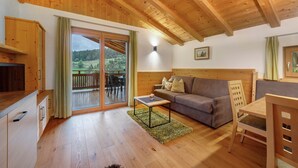 Een houten interieur met een bank, een tafel en een televisie.