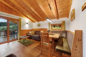 Un interior de madera con una mesa de comedor, sofá y sillas.