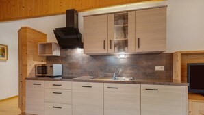 Eine moderne Küche mit Holzausstattung, einer Mikrowelle und einem Spülbecken.