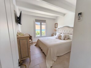 Un dormitorio con cama, escritorio y ventana con vistas.