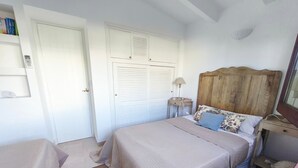 Une chambre à coucher avec un lit, une table de chevet, une lampe et une armoire.