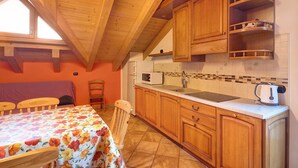 Una cocina con armarios de madera, una encimera, un fregadero y un hervidor.