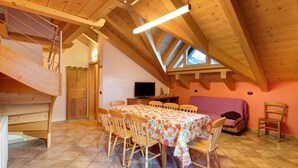 Comedor con una mesa, sillas y un televisor.