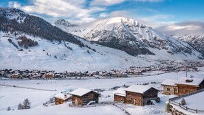Un pueblo nevado con edificios de madera y una vista despejada de las montañas.