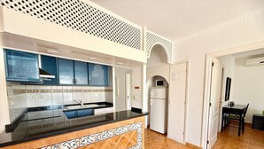 A kitchen with blue cabinets, a black countertop, and a patterned tile backsplash. - Pet Friendly Villa Azul close to the Beach with Pool, Garden, A/C and Wi-Fi (Callao Salvaje, Tenerife)