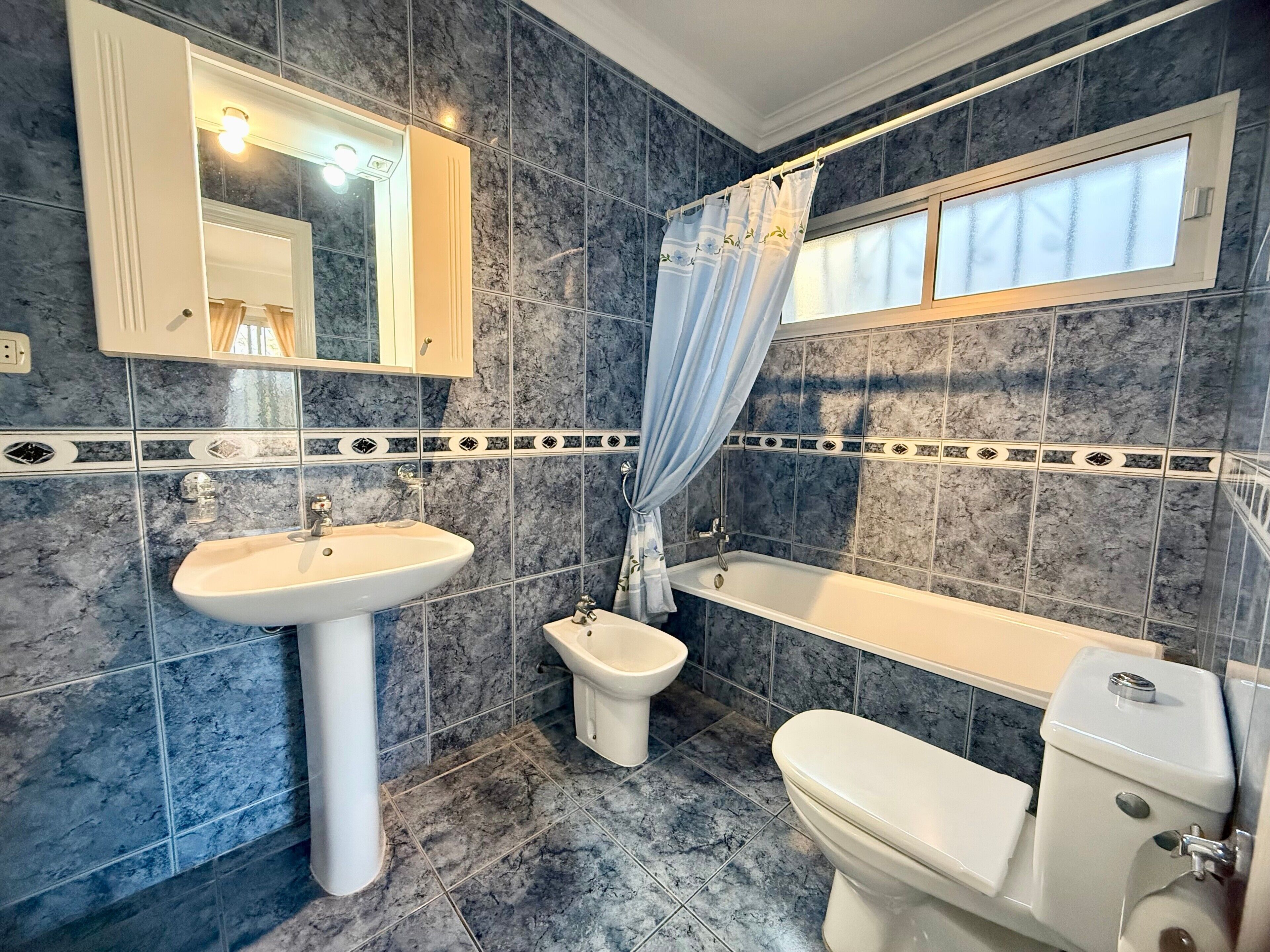 Un baño con lavamanos, bidé, bañera e inodoro.