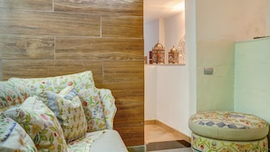 A bedroom with a wooden headboard, floral bedding, and a bedside table with decorative items. - Holiday Home "Casa del Callejón" with Mountain View, Terrace & Outdoor Shower (Tejeda)