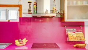 A kitchen with a pink countertop, a built-in stove, and a fruit basket. - Holiday Home "Casa del Callejón" with Mountain View, Terrace & Outdoor Shower (Tejeda)