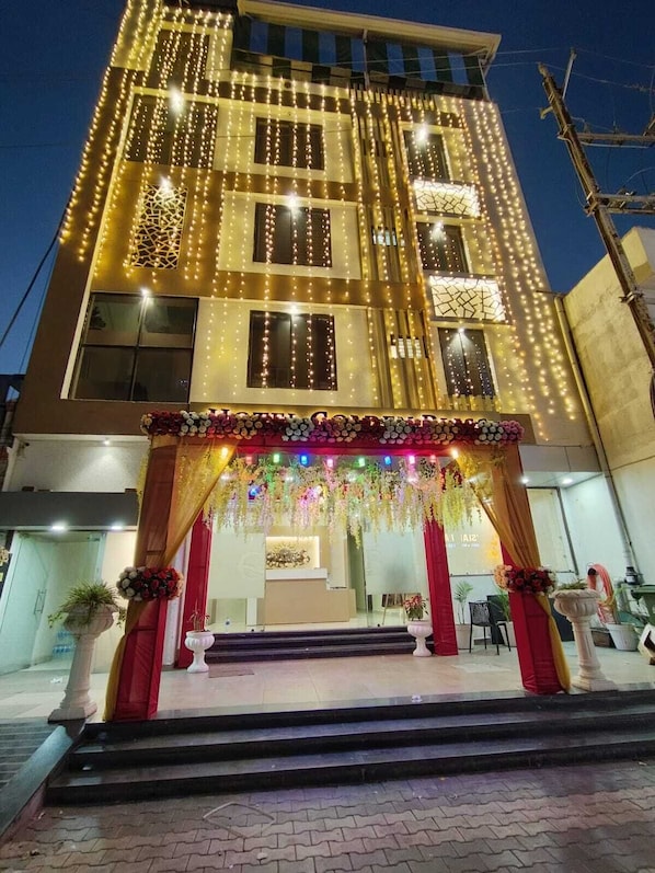 A building with a reception area at the ground level, featuring a staircase leading up to it.