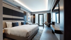 Une chambre d’hôtel moderne, dotée d’un grand lit, d’un bureau et offrant une vue sur la ville.