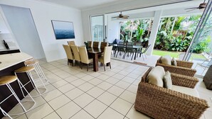 A spacious living area with a dining table, chairs, and a sofa.